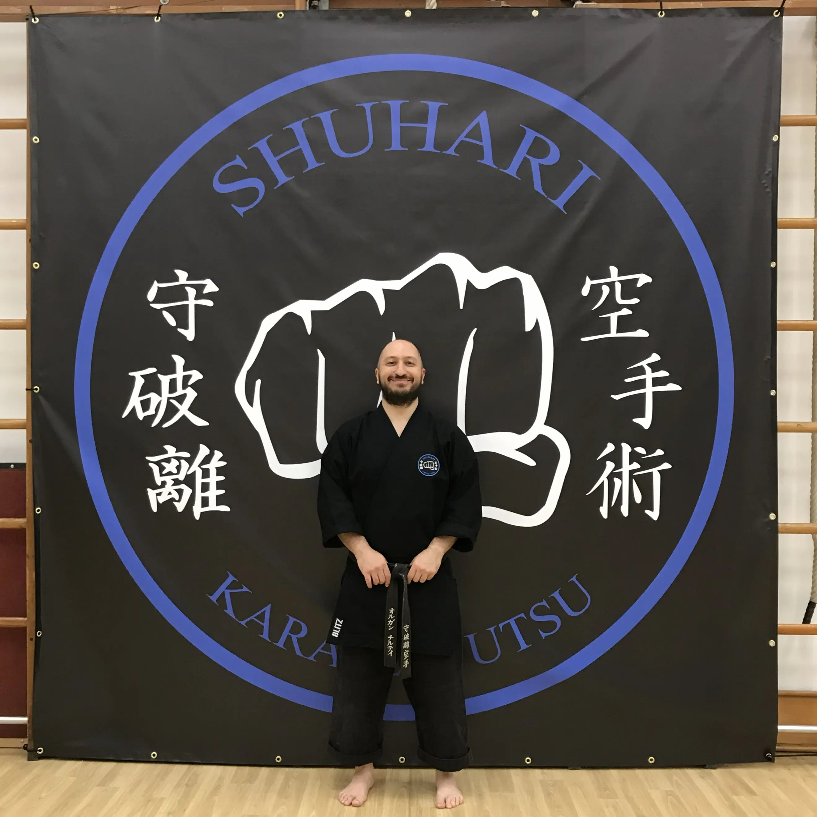 Olgun Tiltay infront of Shuhari banner